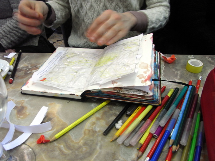 Lorna Collins drawing into her scrapbook