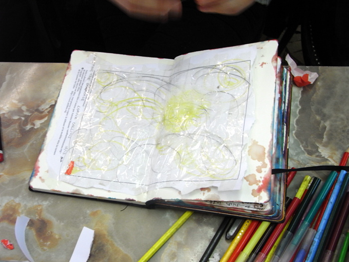 Lorna Collins drawing into her scrapbook